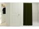Well-maintained bathroom featuring a shower with a green curtain, and an organized closet at 7558 Headwaters Ct, Groveland, FL 34736