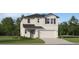 Charming two-story home with a well-manicured lawn, attached garage, and appealing neutral-colored exterior at 7558 Headwaters Ct, Groveland, FL 34736
