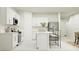 Bright, modern kitchen featuring white cabinetry, stainless steel appliances, and a functional island with seating at 7558 Headwaters Ct, Groveland, FL 34736
