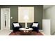 Cozy sitting area featuring accent chairs, stylish lamp and artistic wall decor at 7558 Headwaters Ct, Groveland, FL 34736
