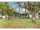 Spacious backyard with lush green grass, mature trees, and an enclosed screened porch at 13219 Meadowlark Ln, Orlando, FL 32828