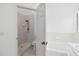 All-white bathroom with tiled shower, separate tub, and abundant natural light for a clean, fresh look at 13219 Meadowlark Ln, Orlando, FL 32828