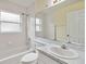 Bathroom with a tub and shower combo, a large mirror, and a single sink vanity with white cabinetry at 13219 Meadowlark Ln, Orlando, FL 32828