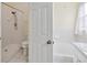 Bathroom featuring walk-in shower and toilet, adjacent to a white door and tub/shower combo at 13219 Meadowlark Ln, Orlando, FL 32828