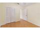 Cozy bedroom with wood flooring, a standard closet, and a doorway leading to another room at 13219 Meadowlark Ln, Orlando, FL 32828