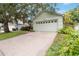 Single-story home featuring a wide driveway leading to a two-car garage, accented by lush greenery at 13219 Meadowlark Ln, Orlando, FL 32828