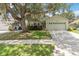 Charming one-story home with a two-car garage, mature landscaping, and a beautiful mature tree at 13219 Meadowlark Ln, Orlando, FL 32828