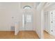 Bright foyer featuring wood-look floors, a skylight, and a charming arched transom window at 13219 Meadowlark Ln, Orlando, FL 32828