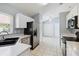 Well-lit kitchen features white cabinets, stainless steel appliances, and tile flooring offers functionality at 13219 Meadowlark Ln, Orlando, FL 32828