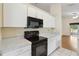 Kitchen with black oven and microwave plus ample storage space with white cabinets at 13219 Meadowlark Ln, Orlando, FL 32828