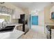 Well-lit kitchen featuring white cabinets, stainless steel appliances, and a double basin sink at 13219 Meadowlark Ln, Orlando, FL 32828
