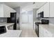 Functional kitchen with white cabinets, black appliances, and neutral countertops offers a practical cooking space at 13219 Meadowlark Ln, Orlando, FL 32828