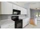 Fully-equipped kitchen with dark appliances, ample counter space, and views to the backyard and adjoining area at 13219 Meadowlark Ln, Orlando, FL 32828