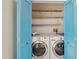 Laundry room with blue closet doors, a washing machine, and a dryer at 13219 Meadowlark Ln, Orlando, FL 32828