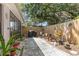 Charming backyard with a stone tile patio, wooden fence, and mature landscaping at 640 Lake Dexter Cir, Winter Haven, FL 33884