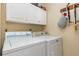 Functional laundry area with white washer, dryer, and storage cabinets at 640 Lake Dexter Cir, Winter Haven, FL 33884