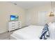 Bright bedroom with a white dresser, TV, and decoratively designed pillows at 7634 Oakmoss Loop, Davenport, FL 33837