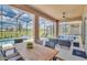 Spacious screened-in patio featuring an outdoor dining area, lounge seating, and views of the pool and backyard at 7634 Oakmoss Loop, Davenport, FL 33837