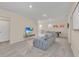 Spacious game room featuring neutral paint and carpet, a gray couch, and an entertainment center with a flat screen TV at 7634 Oakmoss Loop, Davenport, FL 33837