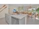 Granite countertops highlight the kitchen island featuring a stainless steel dishwasher and sink overlooking an open floor plan at 7634 Oakmoss Loop, Davenport, FL 33837