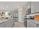 Spacious kitchen with stainless steel appliances, granite countertops, light gray cabinets, and an adjoining breakfast nook at 7634 Oakmoss Loop, Davenport, FL 33837