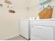 Laundry room featuring a washer, dryer, and decorative signs at 7634 Oakmoss Loop, Davenport, FL 33837