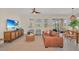 Warm living room with a leather couch, entertainment center, and sliding glass doors to the screened-in patio at 7634 Oakmoss Loop, Davenport, FL 33837