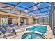 Inviting screened-in pool area with a jacuzzi, lounge chairs, and covered patio seating, perfect for relaxation at 7634 Oakmoss Loop, Davenport, FL 33837