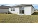 View of a backyard with sliding glass door, an AC unit, and green grass at 2530 Linda Knoll Ln, Bartow, FL 33830