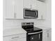 Close up of stainless steel oven and microwave with white cabinets and countertops at 2530 Linda Knoll Ln, Bartow, FL 33830