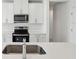 Kitchen with a stainless steel faucet and oven and white cabinets and countertops at 2530 Linda Knoll Ln, Bartow, FL 33830