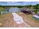 Aerial view of a lake with a wooden dock and lake access. Landscaping is minimal at 1634 Lady Bowers Trl, Lakeland, FL 33809