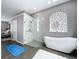 Bright bathroom featuring a standalone shower, soaking tub and colorful glass window at 1634 Lady Bowers Trl, Lakeland, FL 33809