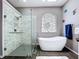 Bathroom featuring glass-enclosed shower, freestanding tub, and stained glass window providing natural light at 1634 Lady Bowers Trl, Lakeland, FL 33809