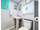 Bathroom boasting a pedestal sink, toilet, storage cabinet, and beach-themed decor at 1634 Lady Bowers Trl, Lakeland, FL 33809