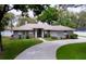 Beautiful single-story home with a manicured lawn, curved driveway, and elegant facade at 1634 Lady Bowers Trl, Lakeland, FL 33809