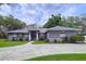 Charming one-story home with well-maintained landscaping and a concrete driveway with some tree cover at 1634 Lady Bowers Trl, Lakeland, FL 33809