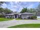 Inviting one-story house showcasing lush green grass, curved driveway, arched windows and tasteful landscaping at 1634 Lady Bowers Trl, Lakeland, FL 33809