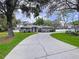 Charming home with a long driveway, lush landscaping, and a well-maintained lawn at 1634 Lady Bowers Trl, Lakeland, FL 33809