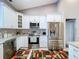 Well-equipped kitchen with stainless steel appliances, white cabinets, granite countertops, and patterned floor rug at 1634 Lady Bowers Trl, Lakeland, FL 33809