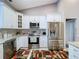Modern kitchen featuring stainless steel appliances, white cabinets, granite countertops, and patterned floor rug at 1634 Lady Bowers Trl, Lakeland, FL 33809