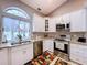Bright kitchen with stainless steel appliances, white cabinetry, and granite countertops at 1634 Lady Bowers Trl, Lakeland, FL 33809