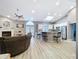 Open-concept living room featuring a fireplace, bar seating at a kitchen island, and light wood flooring at 1634 Lady Bowers Trl, Lakeland, FL 33809