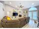 Bright living room with a cozy sectional couch, fireplace, and a view of the backyard through French doors at 1634 Lady Bowers Trl, Lakeland, FL 33809