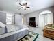 Main bedroom features a ceiling fan, a TV over a fireplace, and a cozy sitting area at 1634 Lady Bowers Trl, Lakeland, FL 33809