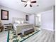 Spacious main bedroom with a neutral color scheme, ceiling fan, and stylish palm tree rug at 1634 Lady Bowers Trl, Lakeland, FL 33809