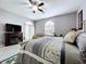 The main bedroom featuring a ceiling fan, a TV over a fireplace, and exercise equipment at 1634 Lady Bowers Trl, Lakeland, FL 33809