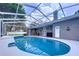 Poolside view of the screened-in pool featuring outdoor seating area and gray home exterior at 1634 Lady Bowers Trl, Lakeland, FL 33809