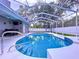 Inviting screened-in pool with tiled accents and a convenient ladder for easy access at 1634 Lady Bowers Trl, Lakeland, FL 33809