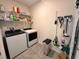 Bright laundry room with new appliances, shelving, and ample space for cleaning supplies at 2987 Neverland Dr, New Smyrna Beach, FL 32168